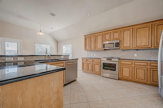 kitchen with light tile patterned floors, tasteful backsplash, decorative light fixtures, stainless steel appliances, and a sink