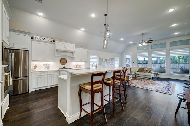 kitchen with open floor plan, light countertops, stainless steel appliances, white cabinetry, and dark wood-style flooring