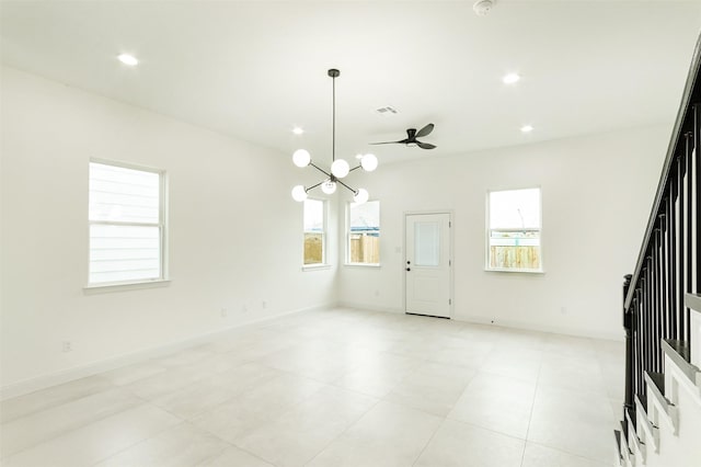 unfurnished living room with recessed lighting, ceiling fan with notable chandelier, stairs, and baseboards