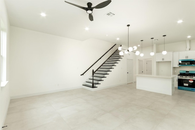 unfurnished living room with recessed lighting, visible vents, stairs, and ceiling fan with notable chandelier