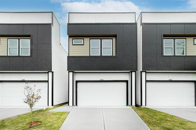 contemporary home with stucco siding, driveway, and a garage