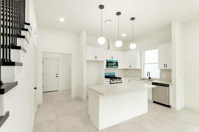 kitchen featuring visible vents, a sink, stainless steel appliances, white cabinets, and pendant lighting