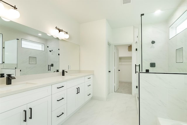 bathroom featuring double vanity, marble finish floor, a stall shower, and a sink