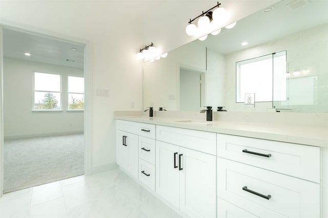 bathroom with double vanity, baseboards, visible vents, and a sink