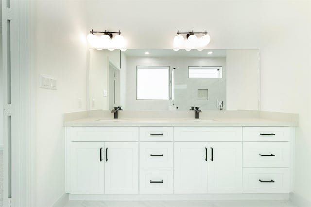 full bathroom featuring a sink, baseboards, a shower, and double vanity