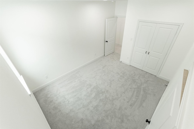 unfurnished bedroom with a closet, baseboards, and carpet