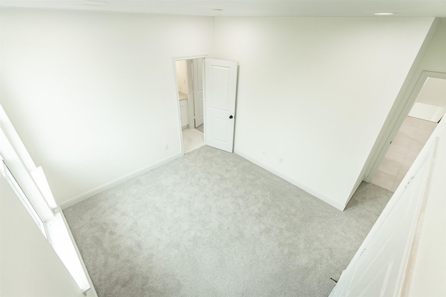 unfurnished bedroom with baseboards and light carpet