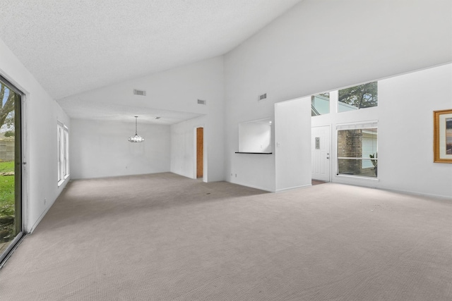 unfurnished living room with a wealth of natural light, light colored carpet, visible vents, and a notable chandelier