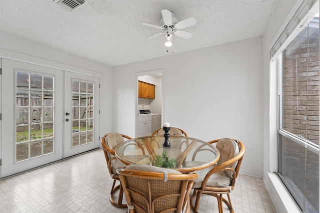 dining room with french doors, light floors, visible vents, a textured ceiling, and separate washer and dryer