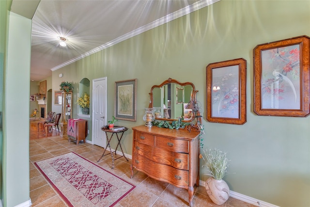 hall with light tile patterned floors, baseboards, and crown molding