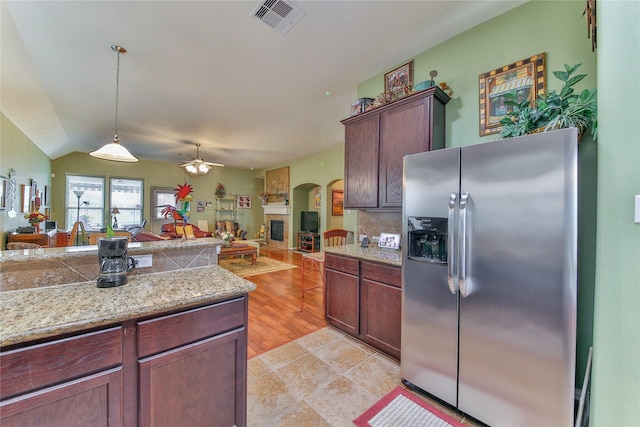 kitchen with pendant lighting, light countertops, visible vents, open floor plan, and stainless steel fridge with ice dispenser