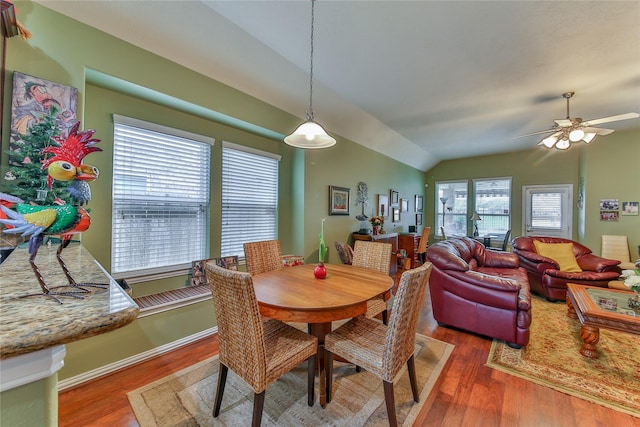 dining room featuring dark wood-style floors, lofted ceiling, ceiling fan, and baseboards