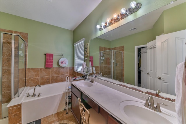 full bathroom with a bath, a stall shower, double vanity, and a sink