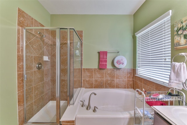 bathroom featuring a stall shower, vanity, and a bath