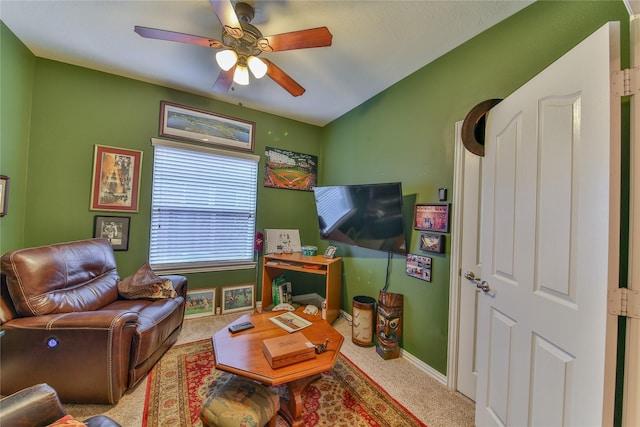 carpeted living area featuring a ceiling fan and baseboards