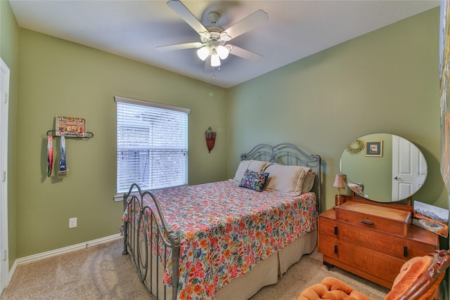 bedroom with a ceiling fan, light colored carpet, and baseboards