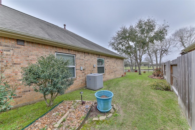 view of yard with central AC unit and a fenced backyard