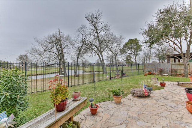 view of patio featuring a water view and a fenced backyard