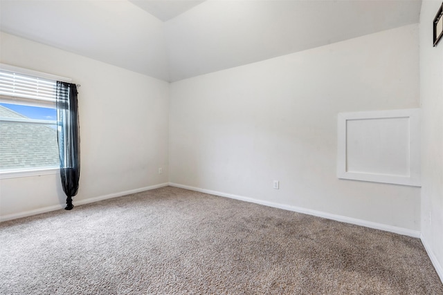 unfurnished room with carpet floors, baseboards, and lofted ceiling