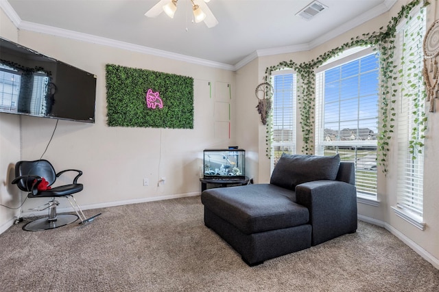 sitting room with carpet floors, visible vents, ornamental molding, a ceiling fan, and baseboards