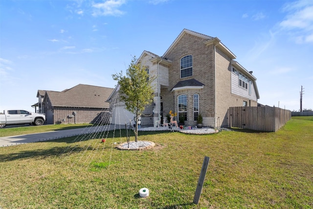 view of front facade featuring brick siding, a front yard, fence, a garage, and driveway