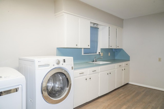 clothes washing area featuring cabinet space, baseboards, wood finished floors, separate washer and dryer, and a sink