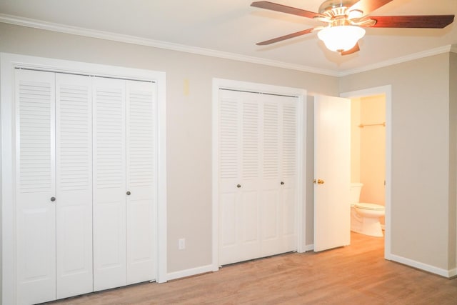 unfurnished bedroom with two closets, light wood-style flooring, ornamental molding, a ceiling fan, and baseboards