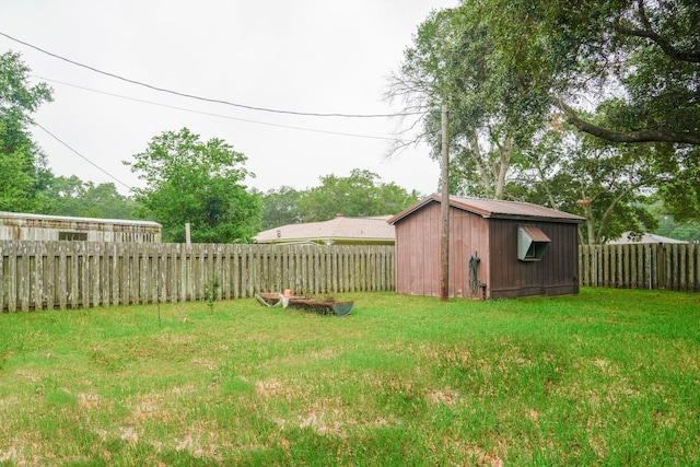 view of yard with a fenced backyard, an outdoor structure, and a shed