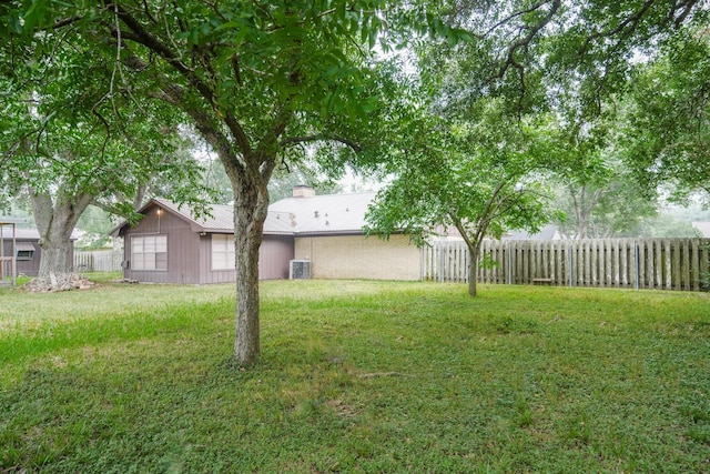 view of yard with fence and central AC unit