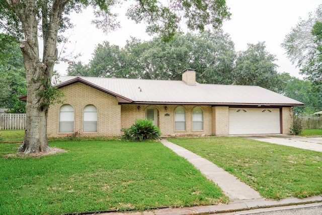 single story home featuring an attached garage, driveway, a chimney, and a front yard