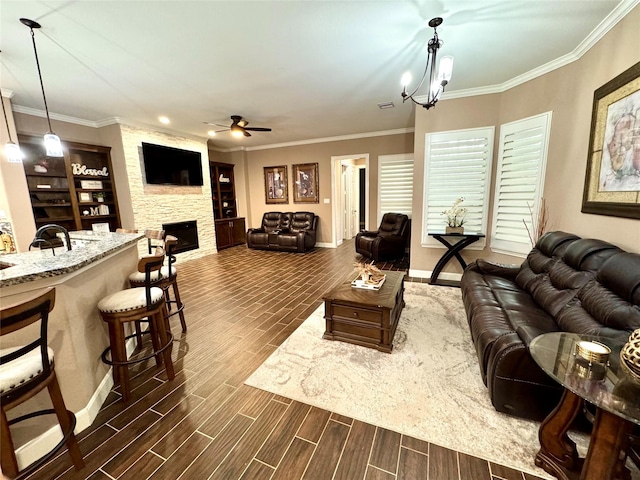 18315 Wisp Willow Way, Porter, TX 77365 - living area featuring a stone fireplace, ceiling fan with notable chandelier, crown molding, and wood finish floors