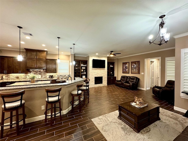 18315 Wisp Willow Way, Porter, TX 77365 - kitchen with visible vents, dark brown cabinets, light stone countertops, wood tiled floor, and a breakfast bar