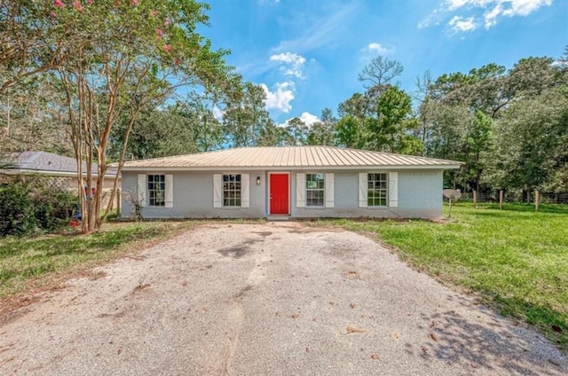 ranch-style home featuring metal roof and a front yard