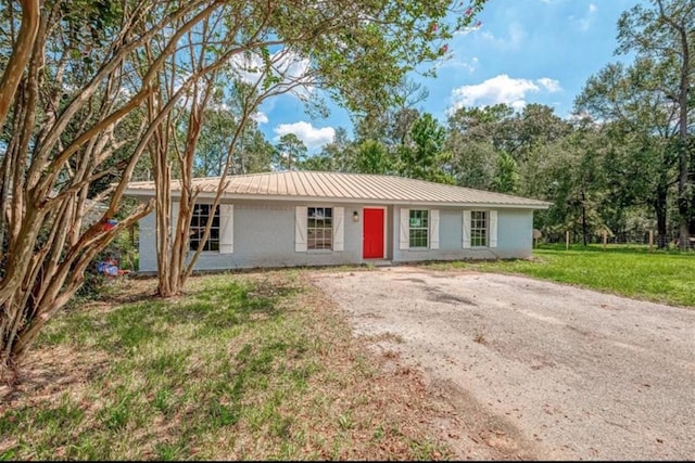 single story home with metal roof and a front lawn