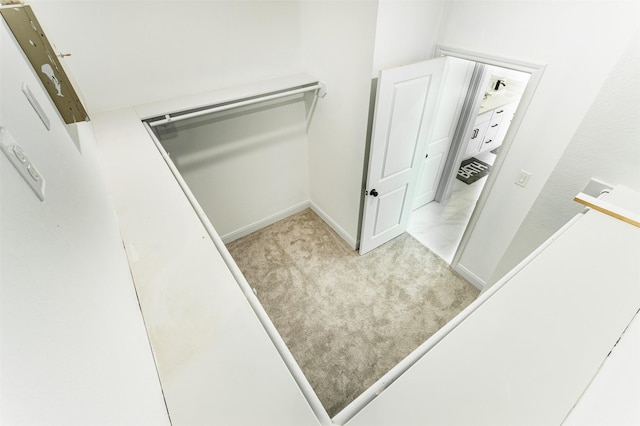 walk in closet featuring light carpet