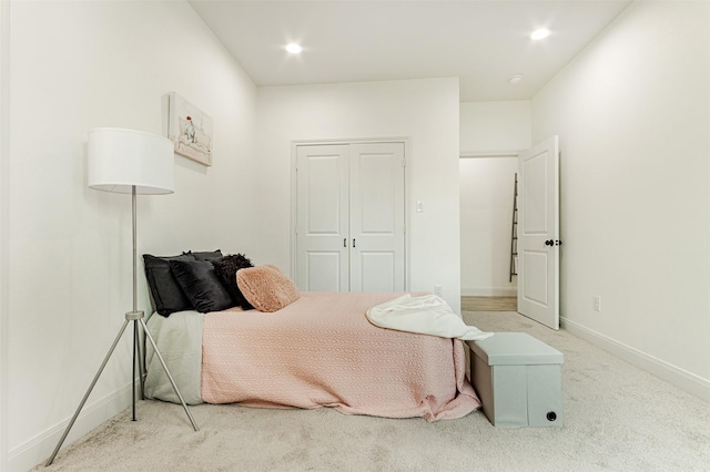 bedroom with recessed lighting, a closet, light carpet, and baseboards