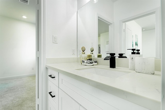 bathroom with baseboards, visible vents, and vanity