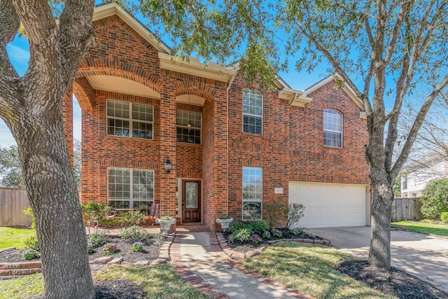 view of front of house with driveway, brick siding, and fence