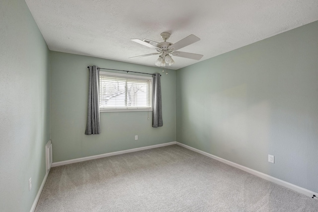 spare room with visible vents, baseboards, ceiling fan, carpet flooring, and a textured ceiling