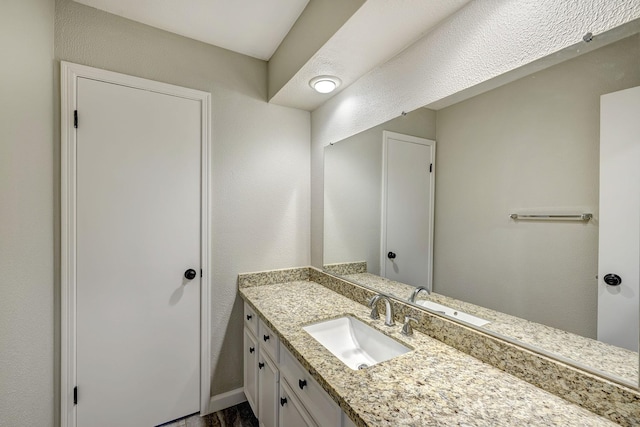 bathroom featuring vanity and a textured wall