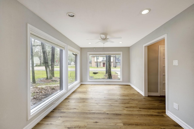 unfurnished sunroom with ceiling fan