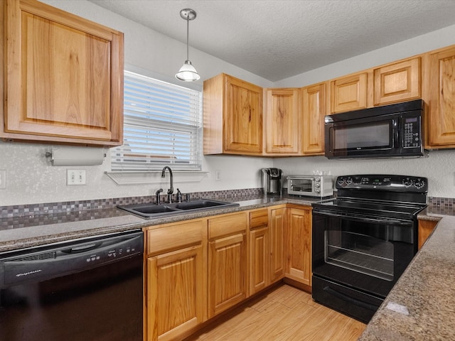 1206 Middle Dr W, Surfside Beach, TX 77541 - kitchen featuring black appliances, light wood finished floors, a textured ceiling, hanging light fixtures, and dark countertops