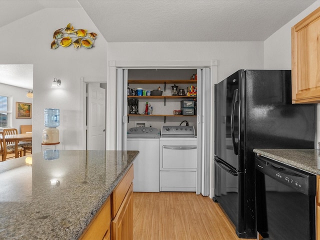 1206 Middle Dr W, Surfside Beach, TX 77541 - kitchen with black dishwasher, light wood finished floors, separate washer and dryer, lofted ceiling, and dark stone counters