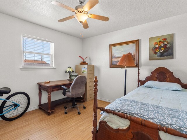 1206 Middle Dr W, Surfside Beach, TX 77541 - bedroom with light wood-type flooring, a textured ceiling, and a ceiling fan