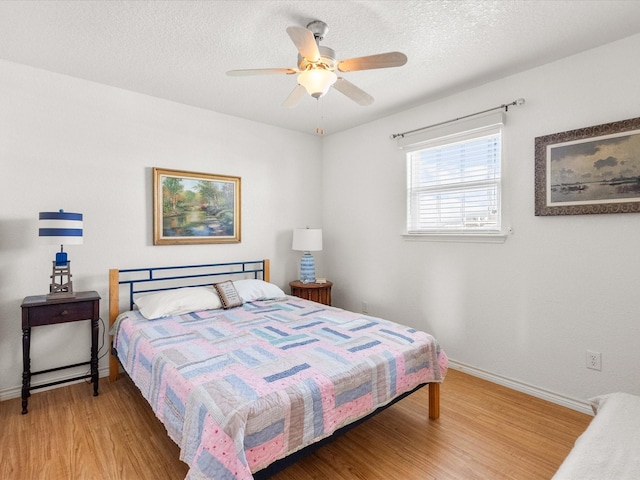 1206 Middle Dr W, Surfside Beach, TX 77541 - bedroom featuring light wood finished floors, a textured ceiling, and a ceiling fan