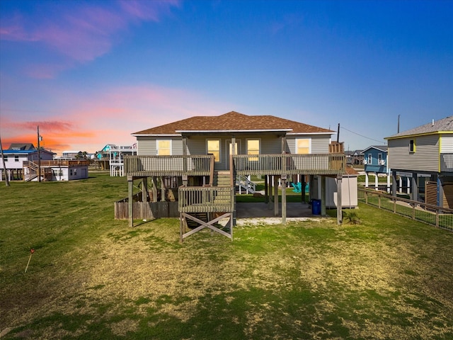 1206 Middle Dr W, Surfside Beach, TX 77541 - back of property at dusk with roof with shingles, a deck, and stairway