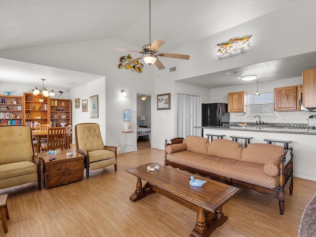 1206 Middle Dr W, Surfside Beach, TX 77541 - living room with light wood-style floors, a ceiling fan, a chandelier, and high vaulted ceiling
