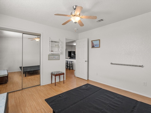 1206 Middle Dr W, Surfside Beach, TX 77541 - bedroom featuring freestanding refrigerator, wood finished floors, a closet, and a ceiling fan