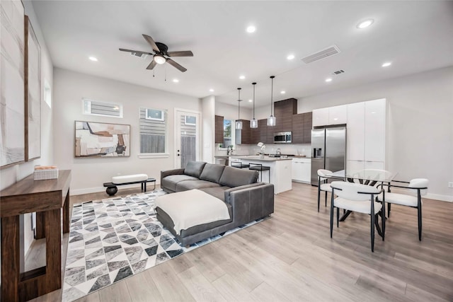 living room with ceiling fan, recessed lighting, visible vents, baseboards, and light wood finished floors