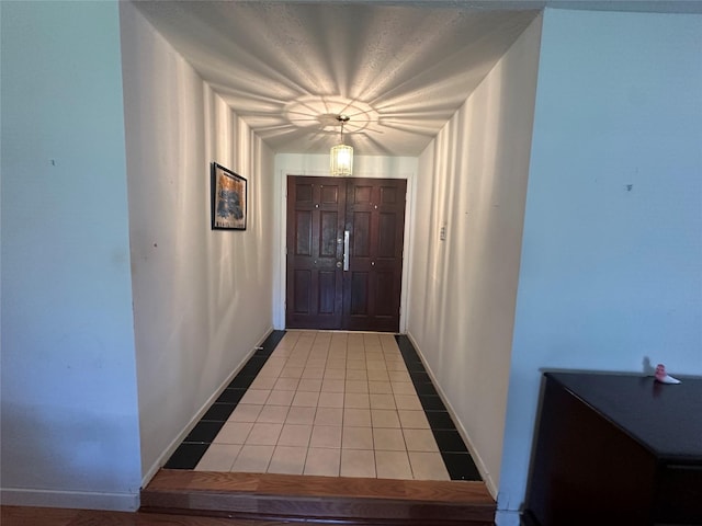 entryway featuring baseboards and light tile patterned floors